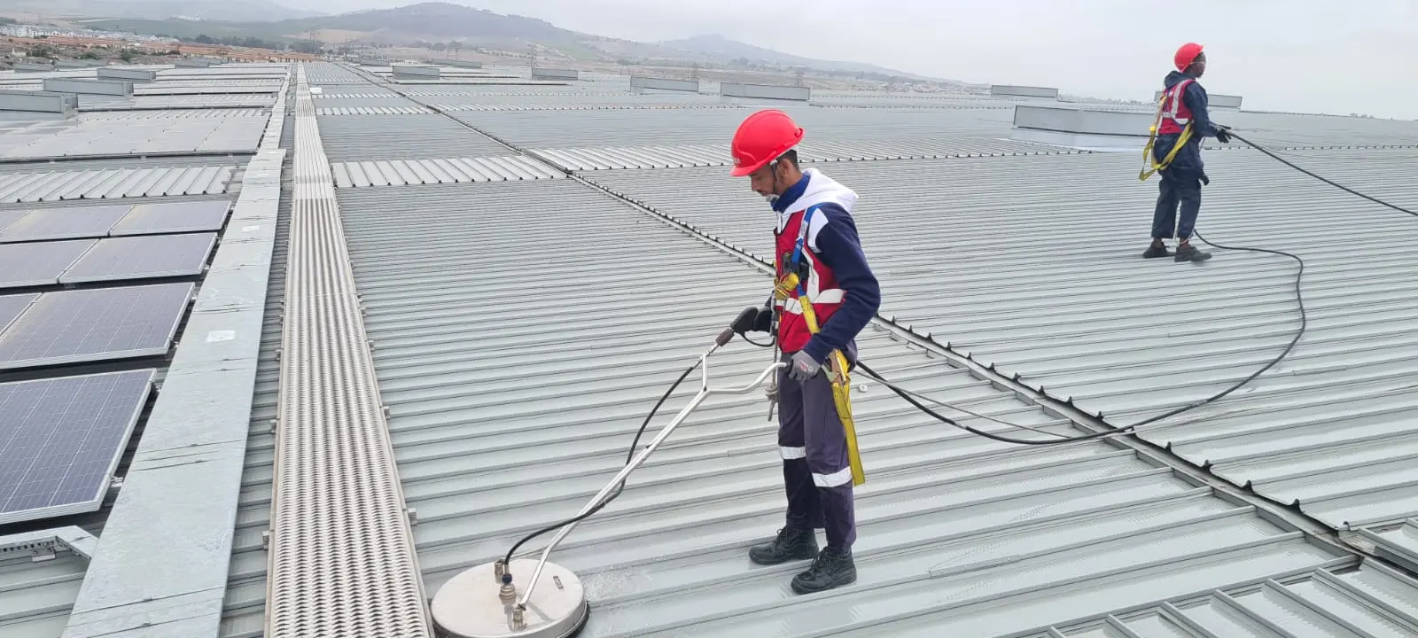 Picture of two Haztech Contract Cleaning employees cleaning a rooftop.